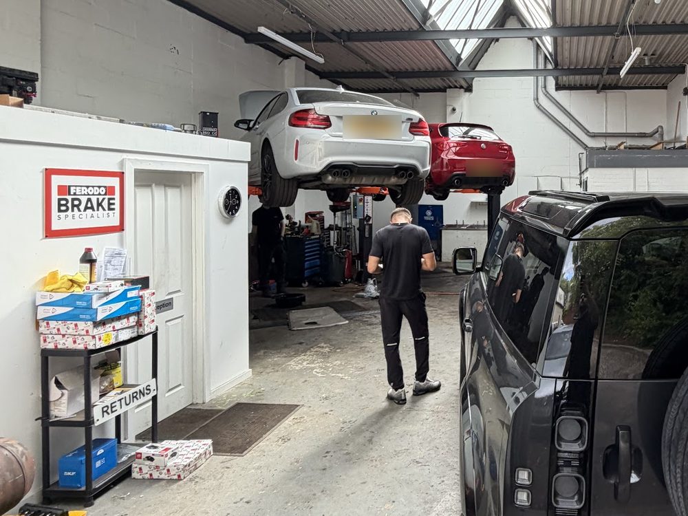 Cars raised on ramps inside the Macdonald Automotive workshop